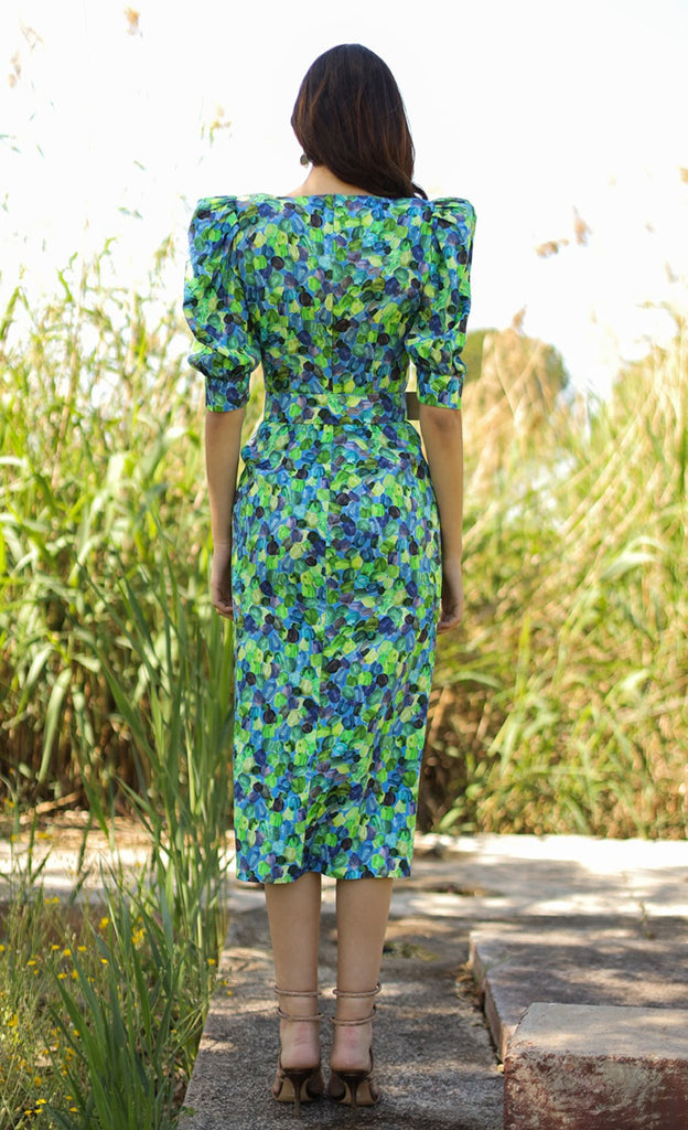 Straight midi dress with round neckline, puffed and elbow-length sleeves, center seam with sewn buttons and belt, and front slit in the skirt. Made of green printed jacquard fabric.